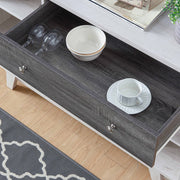 Cropped, angled view of mid-century modern distressed gray and white oak finish buffet server with one drawer open in living space with accessories