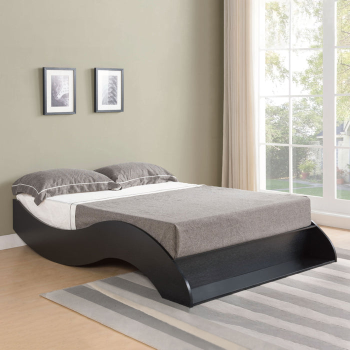 Right-angled black platform bed in a contemporary bedroom. The low-profile design features a curved frame.