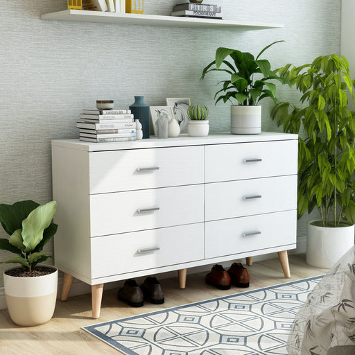 Right angled mid-century modern white six-drawer dresser in a bedroom with accessories