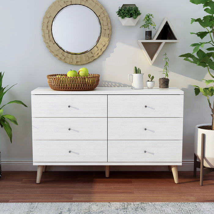 Front-facing mid-century modern white six-drawer dresser in a living area with accessories