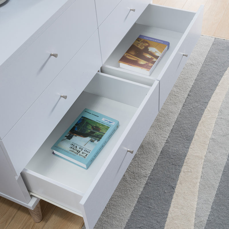 Right angled top view mid-century modern white six-drawer dresser with lower two drawers open in a living area with accessories
