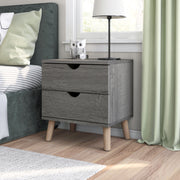 Left angled mid-century modern distressed gray two-drawer nightstand in a bedroom with accessories