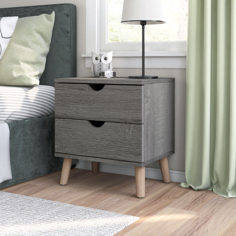 Left angled mid-century modern distressed gray two-drawer nightstand in a bedroom with accessories
