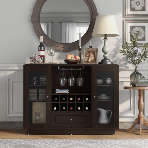 Front-facing espresso wine bar cabinet in a traditional home. Wine glasses hang on the 2 metal stemware racks, while 10 wine bottles are stored in the wine rack. Flanking these are two glass-paneled cabinets with chinaware and a decanter stored on the six shelves. Pink rose, a wine bottle, and wine glasses sit on the left of the tabletop. A bowl of peaches, a frame, and a lamp sit on the right. Above the sideboard is a round mirror.