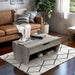 Right angled transitional gray wood lift-top storage coffee table in a living room with accessories