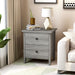 Left angled modern vintage gray oak two-drawer nightstand in a living room with accessories