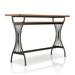 Right angled modern warm oak and metal counter height table with a trestle base on a white background