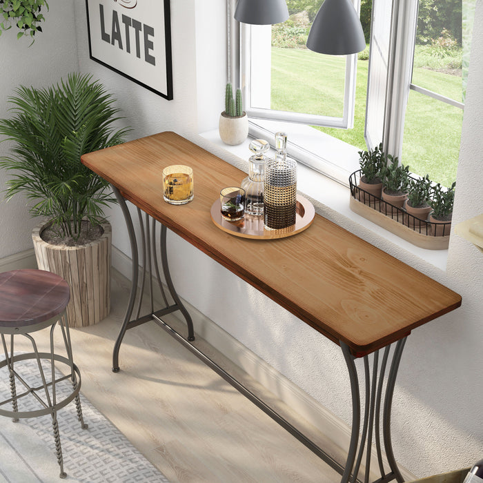 Left angled top view modern warm oak and metal counter height table with a trestle base in a living room with accessories