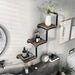 Right-angled industrial staggered three-tier wall shelf with pipe-style framing and reclaimed oak surfaces in an urban bathroom