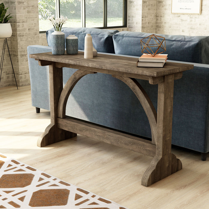 Left-angled rustic reclaimed oak wood finish console table with arch braces in a modern farmhouse living space with accessories