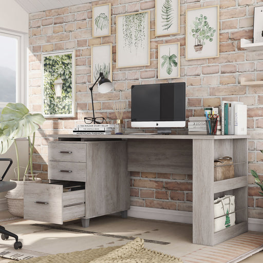 Left angled transitional coastal white office desk with three drawers and one open in a home office with accessories