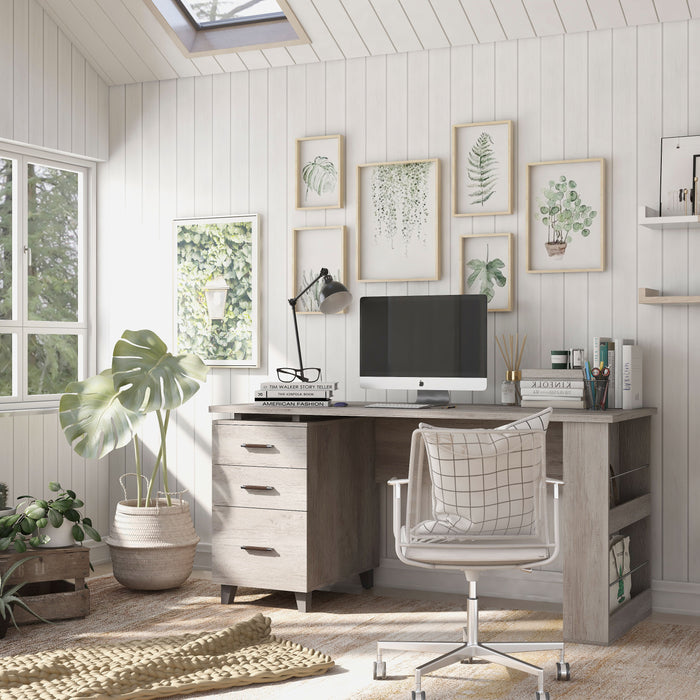 Left angled transitional coastal white office desk with three drawers in a home office with accessories