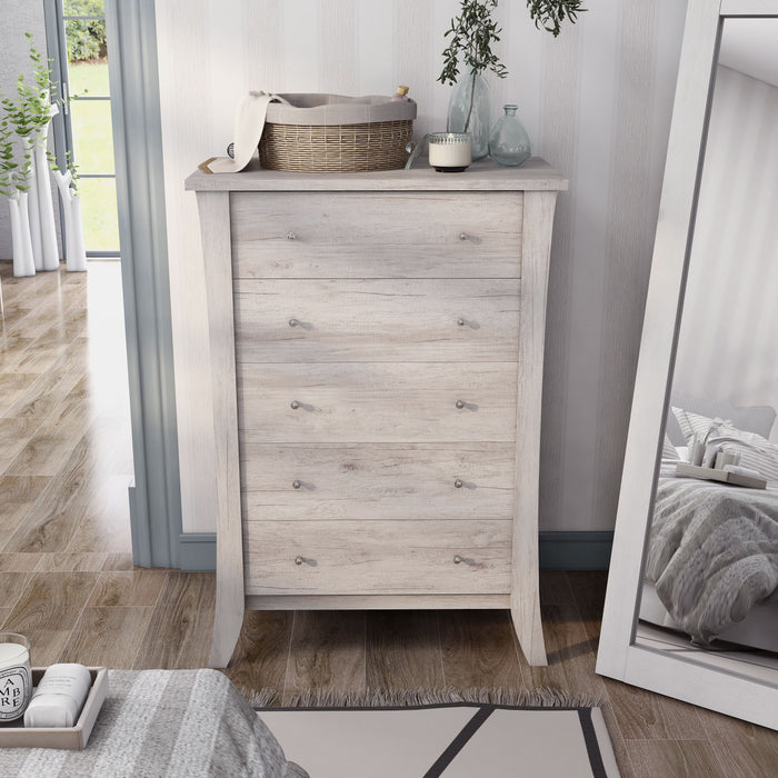 Front-facing transitional coastal white five-drawer tall dresser with splayed legs in a bedroom with accessories