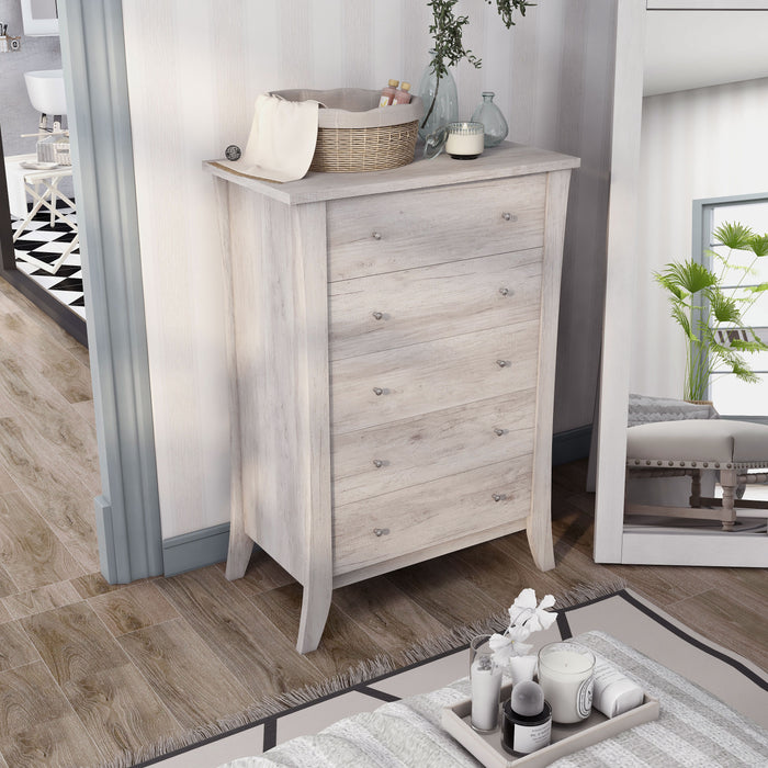 Right angled top view transitional coastal white five-drawer tall dresser with splayed legs in a bedroom with accessories
