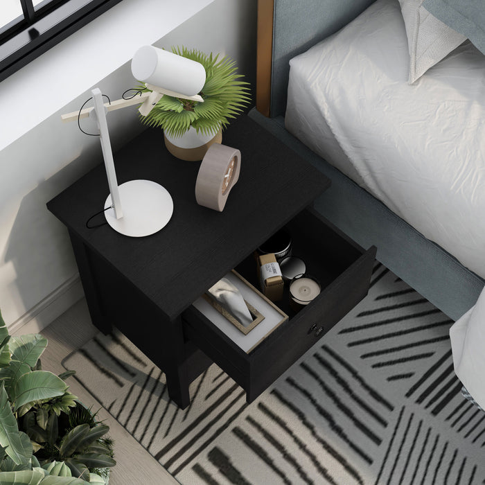 Right angled top view transitional two-drawer black nightstand with top drawer open in a bedroom with accessories