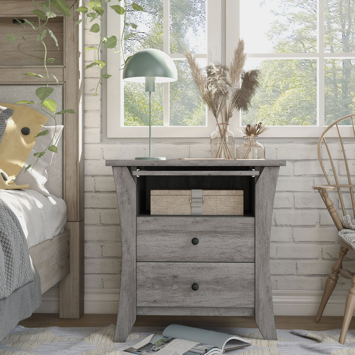 Front-facing transitional vintage gray oak finish wood two-drawer nightstand with flared sides, one fixed shelf, and a pull-out shelf in a modern farmhouse bedroom with accessories