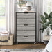 Front facing five drawer dresser in a vintage gray oak finish in a room with accessories