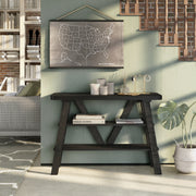 Front facing two shelf console table in a reclaimed black oak finish in a room with accessories