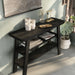 Right angled two shelf console table in a reclaimed black oak finish in a room with accessories