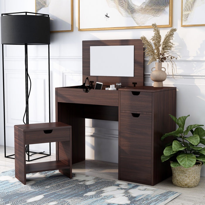 Left-angled walnut vanity table set with stool in a contemporary bedroom. The lift-top table reveals an underside mirror and compartmentalized storage. Two grooved handles on the table and one grooved handle on the stool indicate more storage space.
