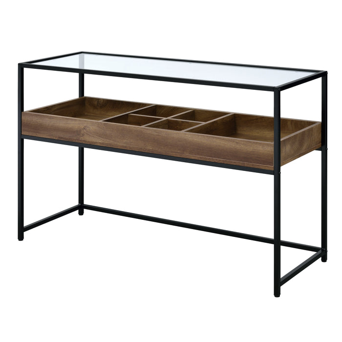 Left-angled mixed material console table against a white background. A matte black steel frame holds a glass top for an open and airy design. Below the tabletop is a compartmentalized shelf. Two large compartments flank four smaller compartments in a warm wood color.