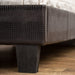 Detail shot of the brown faux crocodile leather footboard and tapered black foot.